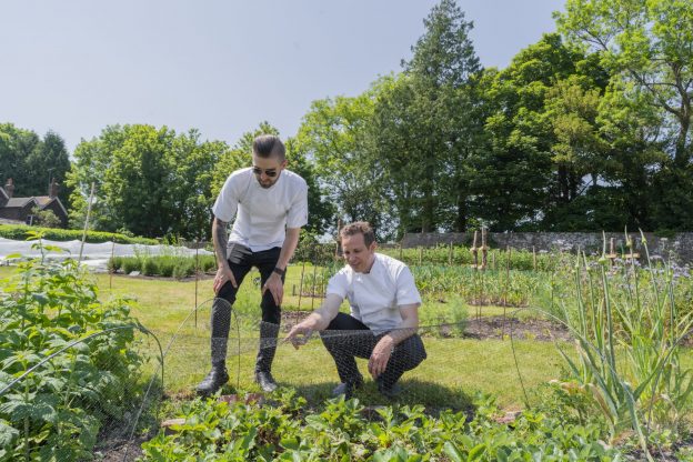 Chefs Tom Kemble and Jordon Powell looking at vegetable produce at Wiston walled garden.